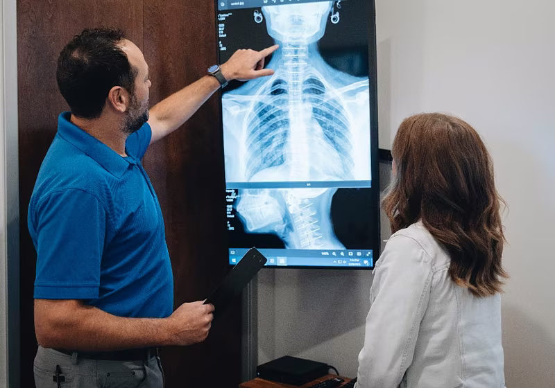 Dr. Michael P. Henry reviewing a neck x-ray with a patient