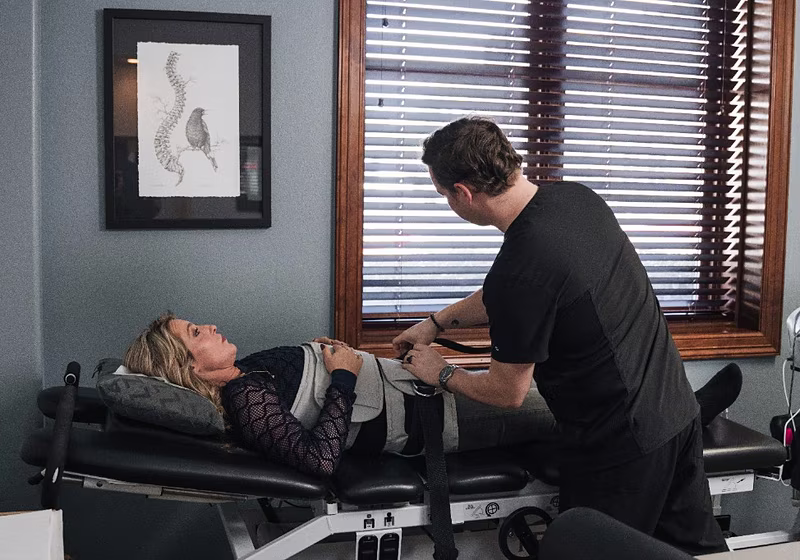A clinician fitting a spinal decompression harness