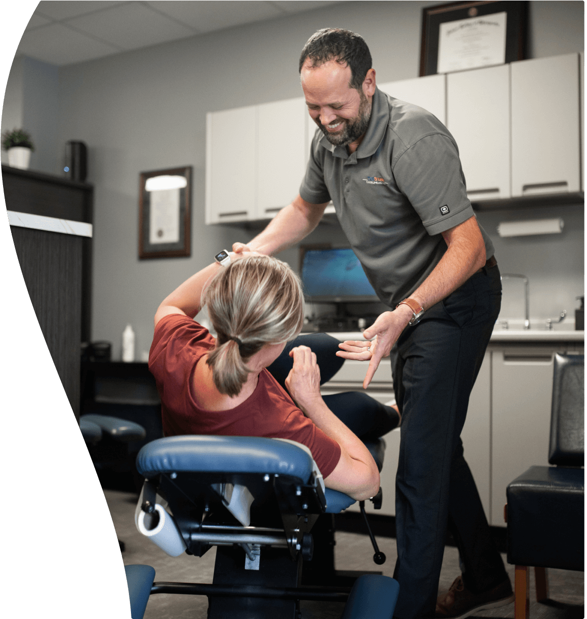 Dr Henry assisting a client off the chiropractic table