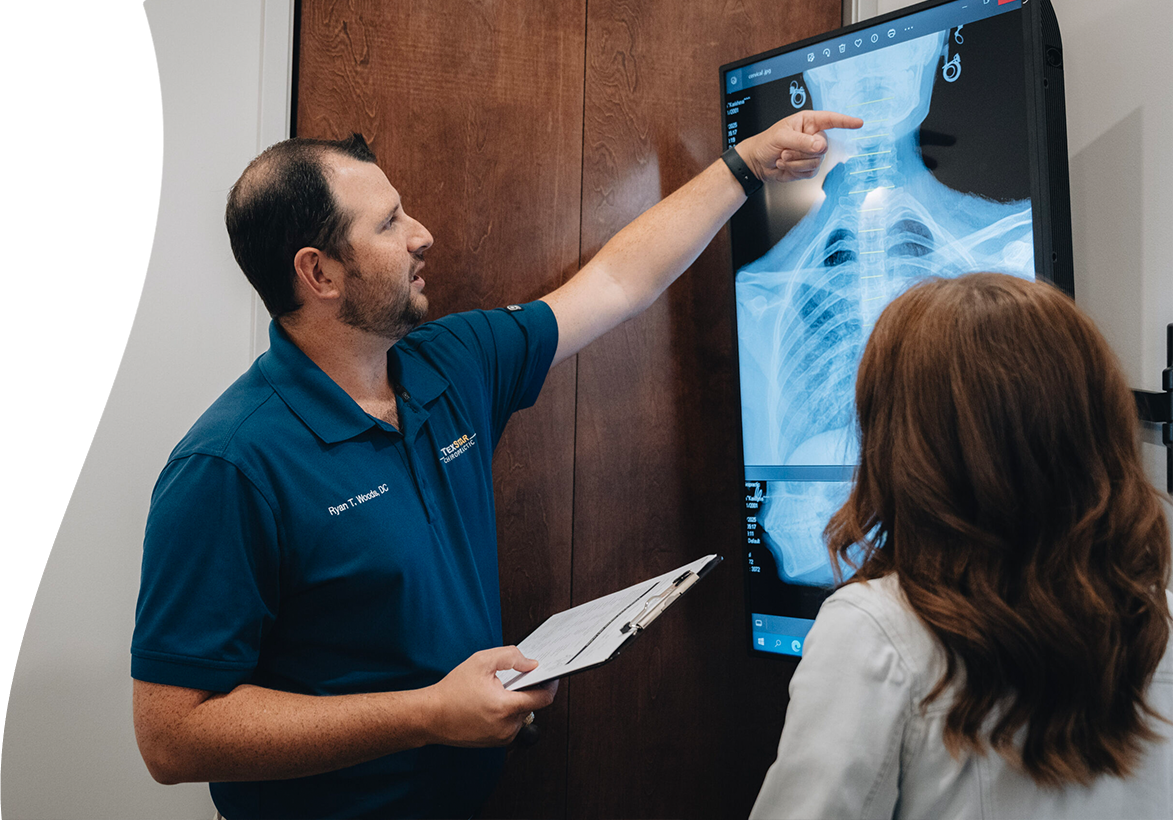 Dr. Ryan Woods showing an x-ray to a patient